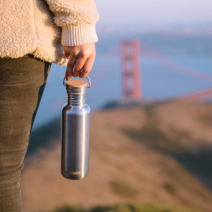 27oz-reflect-with-bamboo-cap-l2 K27SSLRF-BS-BAMBOO_reflect_bottle_bridge_lifestyle.jpg